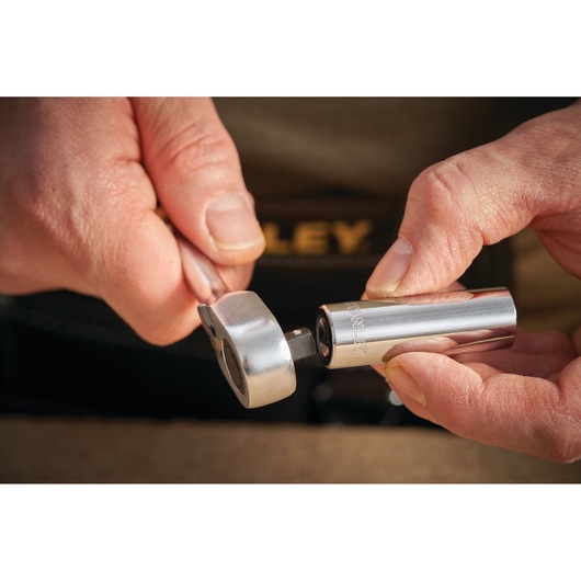 STANLEY STMT86098-0 socket wrench held in hand with chrome socket being attached, close-up photography.