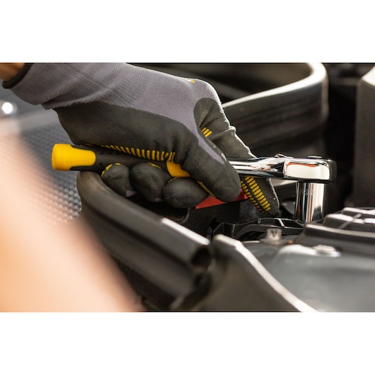 STANLEY STMT86315-0 ratchet wrench in use, close-up of gloved hand working on engine.