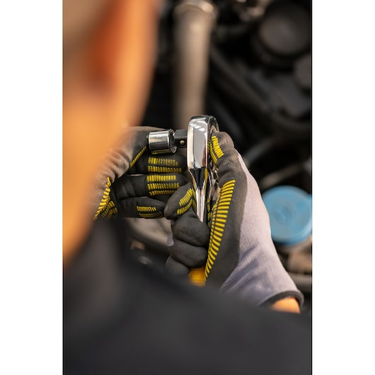 STANLEY STMT86509-0 ratchet tool held by gloved hands, automotive context, close-up photography.