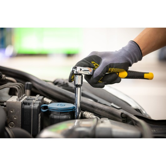 Photo of STANLEY STMT88930-0 ratchet wrench in use, tightening bolt in car engine compartment.