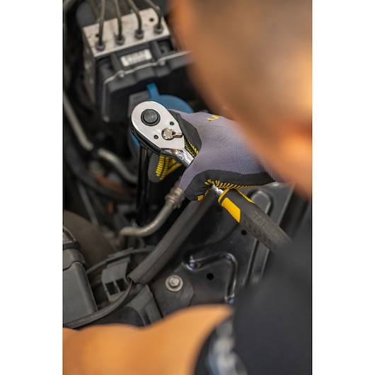 Photo of STANLEY STMT88942-0 ratchet wrench with yellow and black handle in use on car engine.