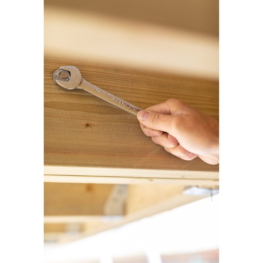 STANLEY STMT89918-0 wrench in use tightening a bolt on wood, close-up, product category Photography.