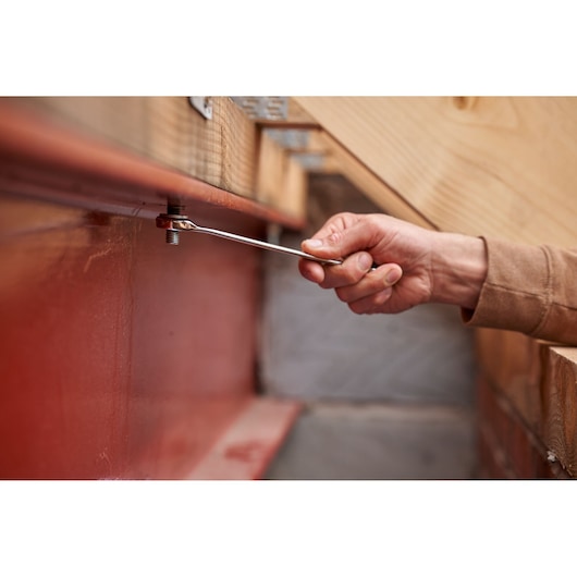 Photo of STANLEY STMT98109-1 wrench from Maintenance Suitcase 142PCS tightening bolt on red metal beam.