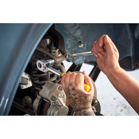 Photo of STANLEY STMT98109-1 ratchet wrench in use under car, from STANLEYMaintenanceSuitcase142PCS kit.