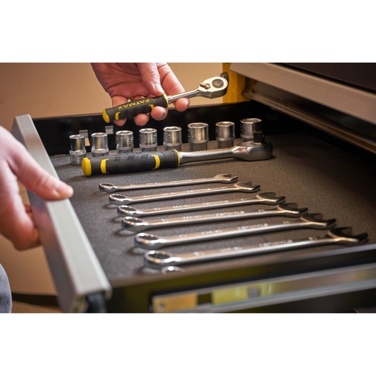 STANLEY STST74306-1 photography of hand holding ratchet in drawer with wrenches and sockets.