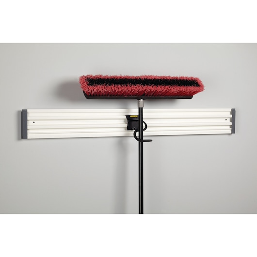 STANLEY STST82605-1 wall-mounted storage rail with broom and hook attachment, front angle.