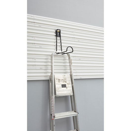 STANLEY STST82614-1 ladder hanging hook on white wall panel, front angle.