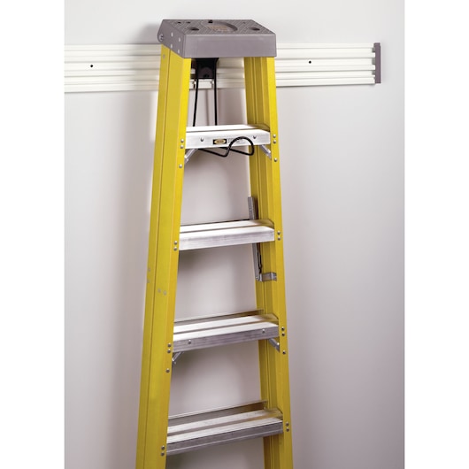 STANLEY STST82614-1 yellow ladder hanging on wall-mounted rack, front angle photo.