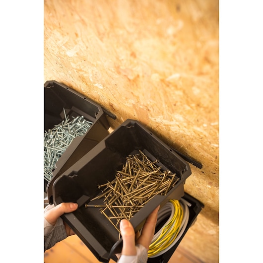 STANLEY STST82734-1 black storage bin with gold screws, wall-mounted, photography close-up.
