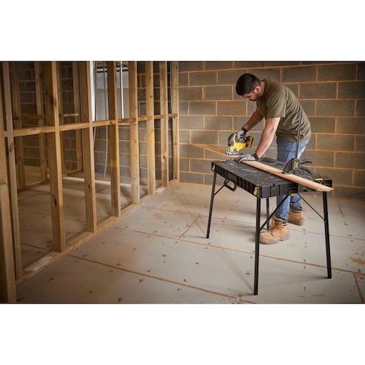 STANLEY STST83492-1 work table used for sawing wood in a construction photography scene.