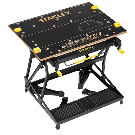 STANLEY STST83800-1 folding workbench with black tabletop, yellow clamps, and metal frame, angled view on white background.